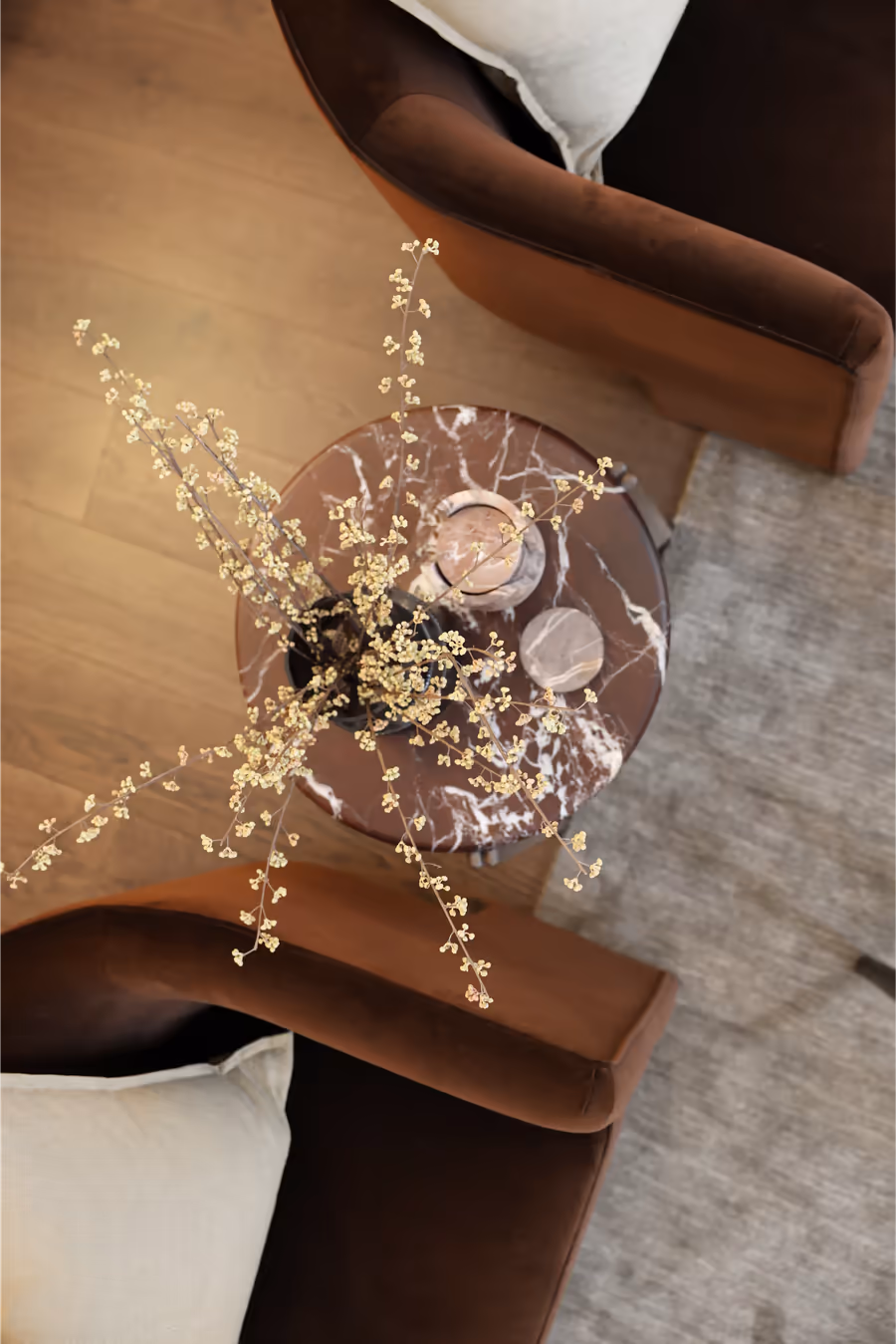 Looking down on a marble side table set between chocolate velvet armchairs