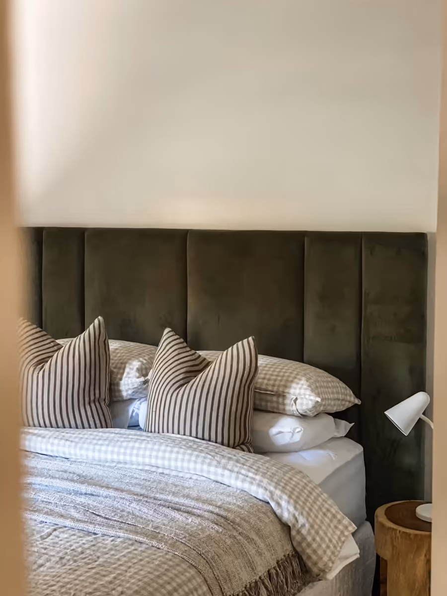 Olive velvet bedhead with striped and gingham bedding